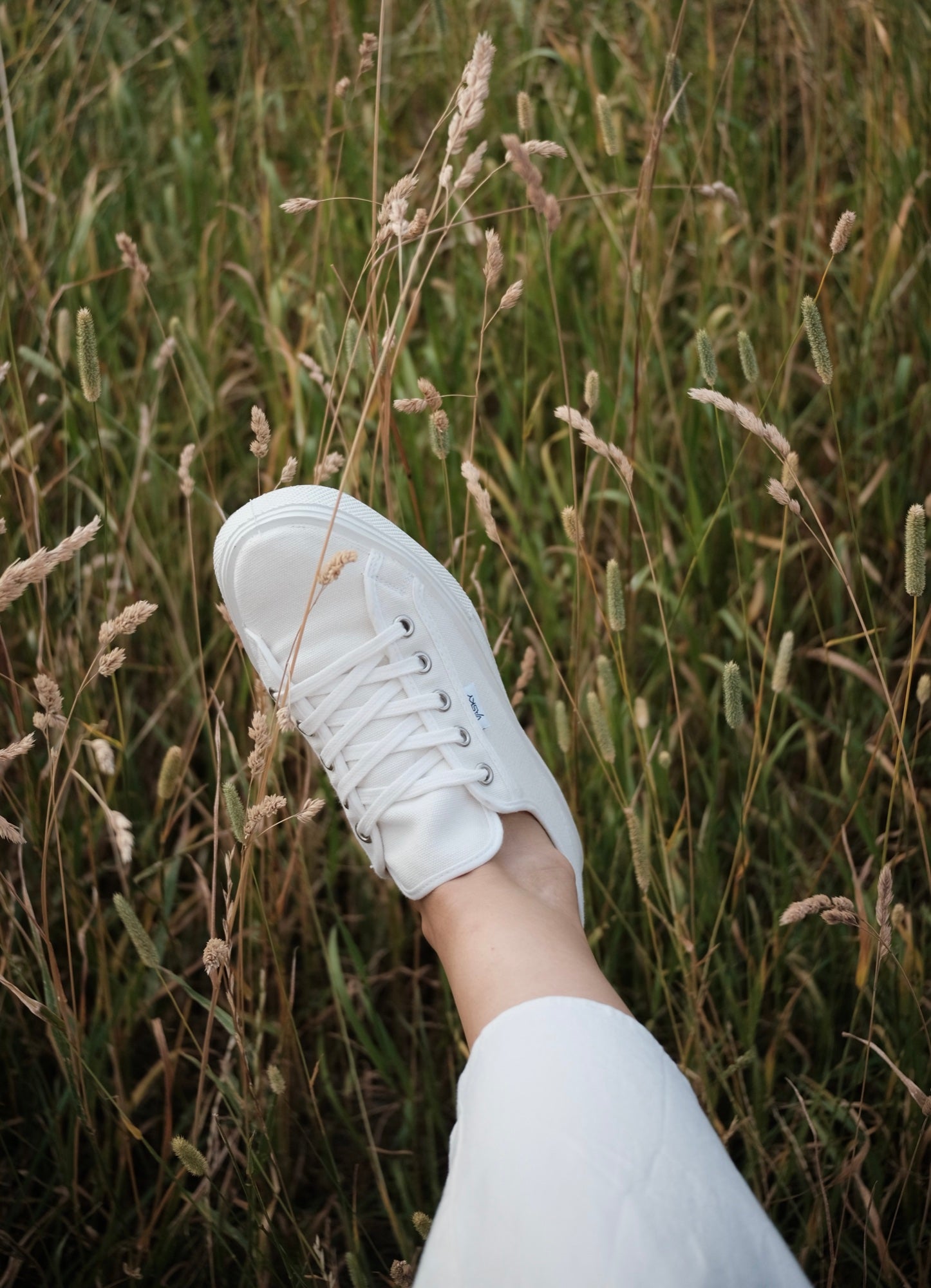 Bílé plátěné tenisky Vasky Kanvy White – lifestyle v trávě